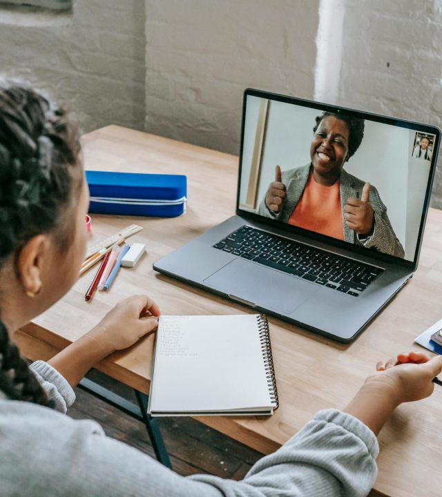 A young student connecting with a teacher via video call for an online lesson.